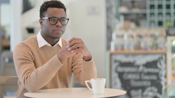 African American Man Feeling Worried While Drinking Coffee in Cafe