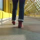 Women's Legs in Burgundy Boots and Blue Jeans Walk on a Closed Pedestrian Bridge - VideoHive Item for Sale