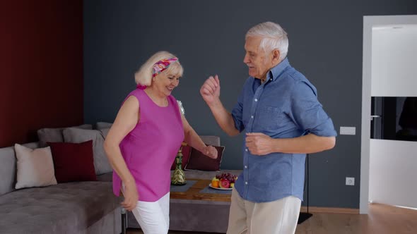 Senior Mature Couple Dancing Together in Room at Home During Quarantine Lockdown for Coronavirus