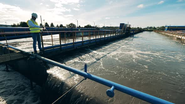 Male Specialist Is Testing Water From the Sewage Cleaning Plant