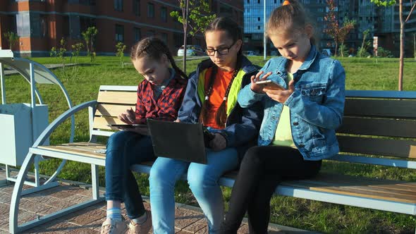 A Group of Children Sitting on a Bench