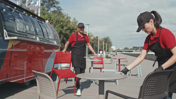 Food Truck Workers Arranging Seating Outdoors