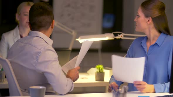 Business Team with Papers Working Late at Office 