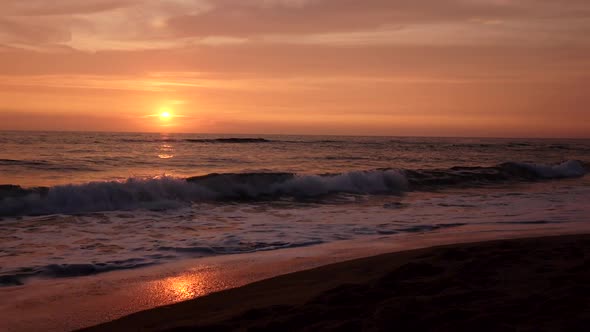 Tidal Waves of the Sea in Beams of a Pink Sunset