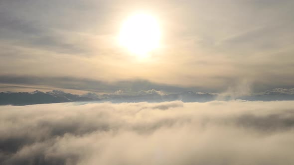 Incredible Aerial View Shot Above Swirling Fog and Clouds at Sunset in the Mountains