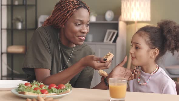 Female Soldier and Little Girl Eating Sandwiches at Home alt