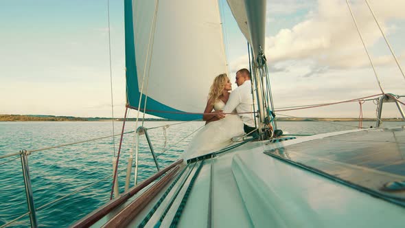 The Newlyweds Are Sailing on the Lake Aboard the Yacht. They Enjoy Each Other, Look and Smile