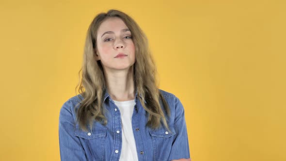 Young Pretty Girl Looking at Camera on Yellow Background