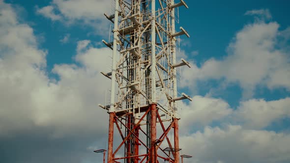 Broadcasting TV Tower Against Blue Sky with White Clouds