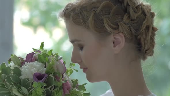 Young Blonde Girl in White Vintage Dress Enjoys Smeling Flowers, Slow Motion