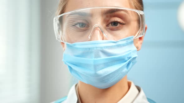 Concentrated lady doctor in blue disposable facial mask