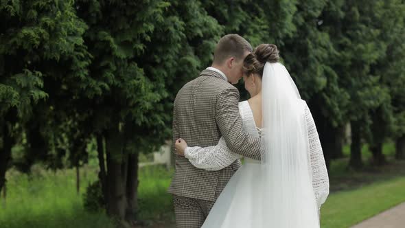 Newlyweds. Caucasian Groom with Bride Walking in Park. Wedding Couple. Man and Woman in Love