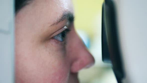 A Woman is Getting Her Eyes Examined By a Medical Mechanism