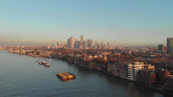 Dolly forwards drone shot towards London canary wharf buildings over Thames river