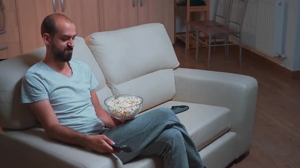 Concentrated Man Sitting in Front of Television Using Control Remote