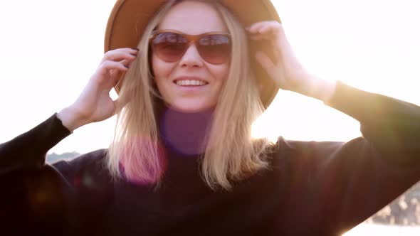 Caucasian Blonde Woman with Beige Hat in Black Sweater Wear Sunglasses in the Countryside