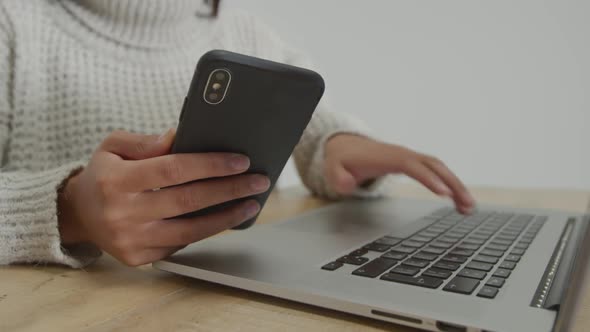 Woman using laptop and smartphone