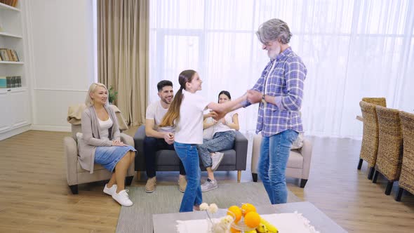 Big Multigenerational Family Dancing and Having Fun Together While Relaxing in Living Room at Home