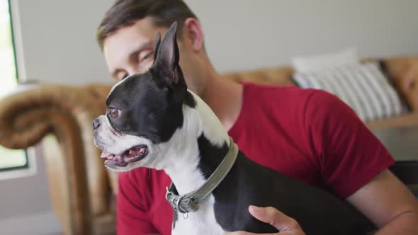 Caucasian man is playing with his dog at home