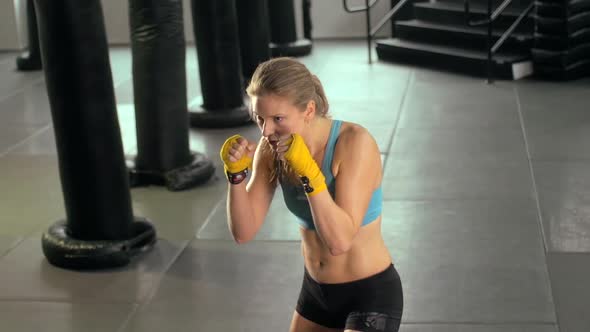 Woman doing Muay Thai kickboxing training at the gym.
