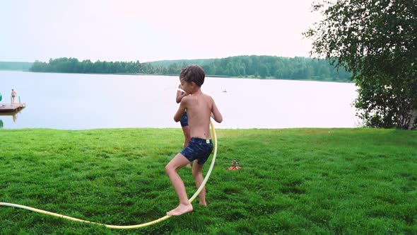 The Two Boys Are Playing with Mom and Dad in the Backyard of Their House Drenching with Hose Water