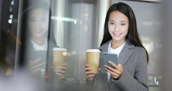 Business woman use of mobile phone inside office