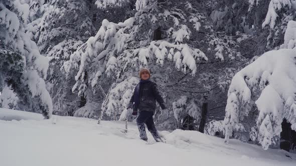 Boy playing in the snowy forest.