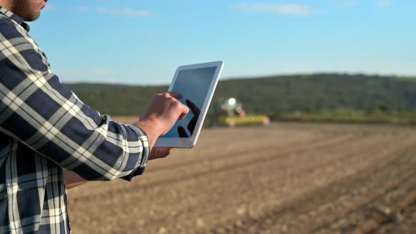 Farmer Man Read or Analysis a Report in Tablet Computer on Agriculture Field