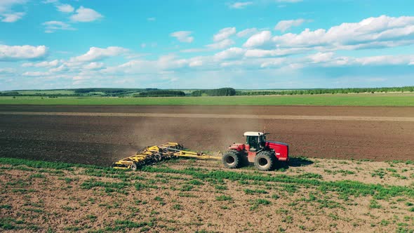 One Agricultural Tractor Drives on a Field, Sowing Seeds