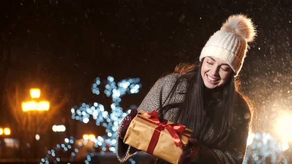 Beautiful Young Girl Unpacks Her Box with a Christmas Gift