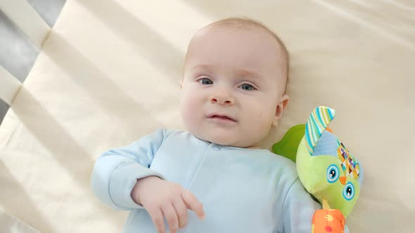 POV of Parent Looking on Little Baby Boy Playing with Toy in Cradle