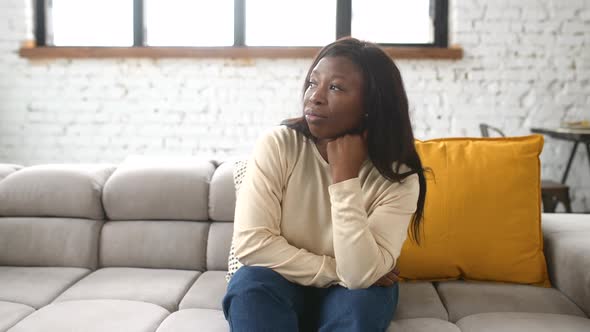 Upset Young Woman Sitting on the Sofa