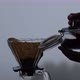 A woman putting ground coffee into a dripper to making drip coffee - VideoHive Item for Sale