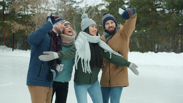 Funny Friends Taking Selfie with Smartphone Posing Standing in Ice-skating Rink