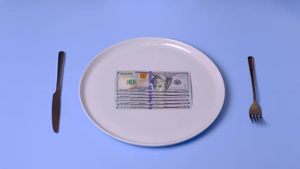 Hands Try to Eat a Dollar Bill on the Plate Using Cutlery  Video