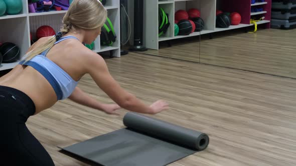 Beautiful woman with flexible body doing yoga exercises in the gym