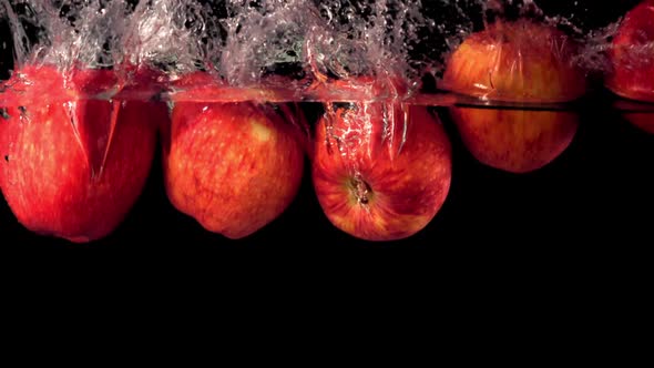 Super Slow Motion Fresh Apples Fall Under the Water with Splashes