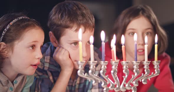 Kids watching hanukka candles burning