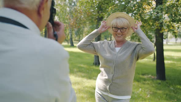 Slow Motion of Mature Woman Posing for Photo Camera Having Fun with Husband in Summer Park