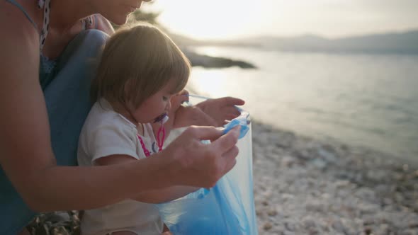 Mamaz Child Cleans Garbage on the Beach By the Sea