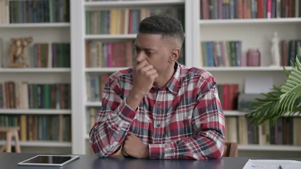 Upset African Man Feeling Worried While Sitting in Office