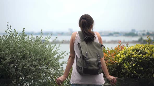 Young Woman with Backpack Enjoying View of the Landscape From the Hotel