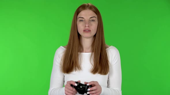 Portrait of Pretty Young Woman Is Playing a Video Game Using a Wireless Controller and Loses.