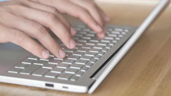 Close Up of Fingertips Typing On Laptop