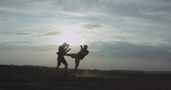 Silhouettes Performance of Martial Art Among Space on Huge Sun Background