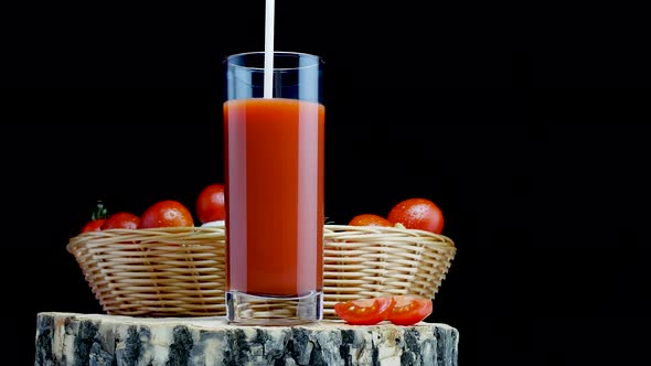 Pour Natural Tomato Juice Into A Glass On A Black Background. Fresh Tomatoes With Tomato Juice