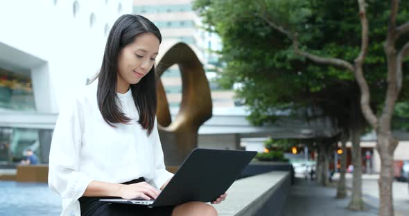 Business woman use of laptop computer in city