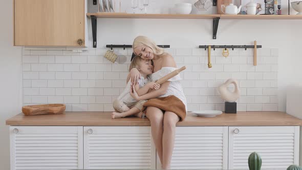Blonde Woman with Her Son in the Kitchen