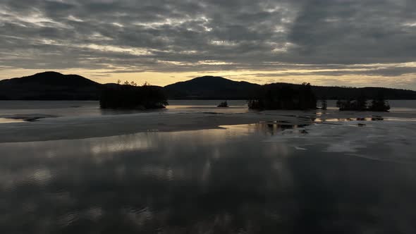 Sunset beyond calm frozen lake Winter Aerial