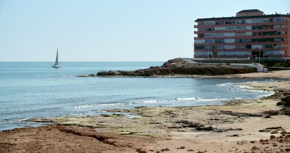 Sailing Yacht on Horizon of the Mediterranean Sea at Sunny Summer Day Calm Water